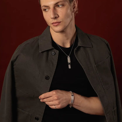 Close-up of male model wearing a sterling silver double dog tag necklace and engraved ID bracelet
