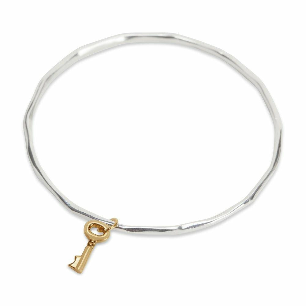 silver bangle with gold key charm attached