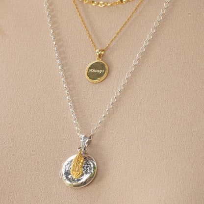 white gold belcher chain on a feather locket with gold feather charm