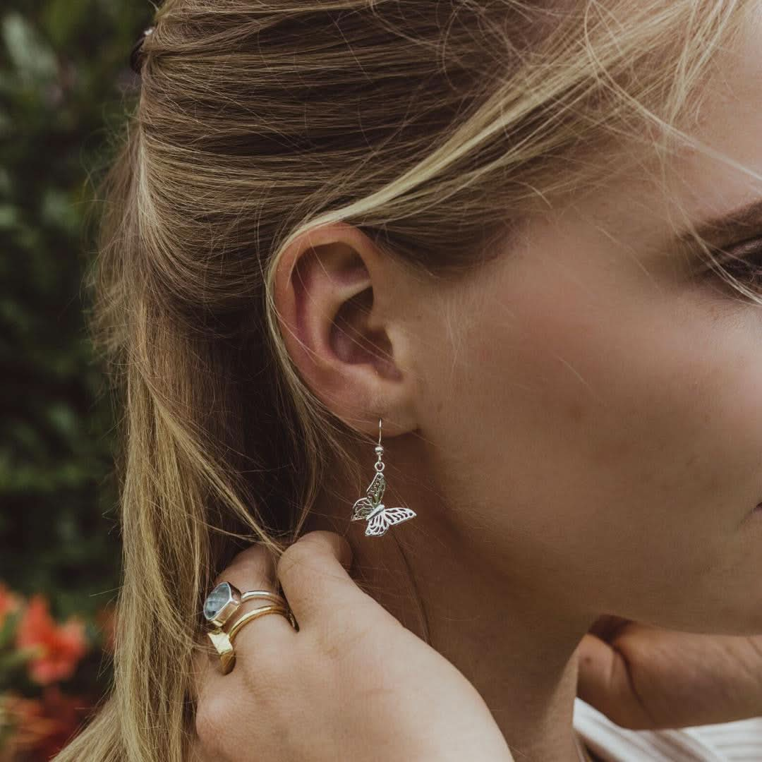 close up of model wearing silver butterfly earrings 