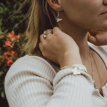 close up of model wearing butterfly bangle  