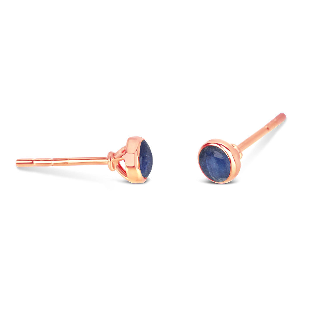 Sapphire mini stud earrings in rose gold facing the side on a white background