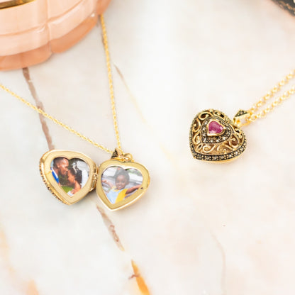 opened ruby vintage heart locket with photos inside