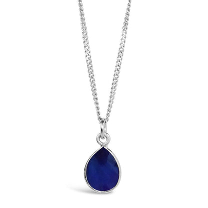 sapphire charm necklace in silver on a white background