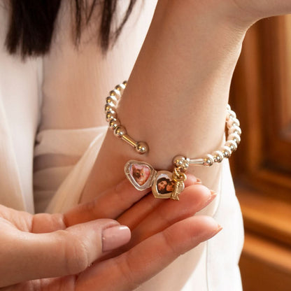 model wearing heart locket bangle in silver showing photos inside