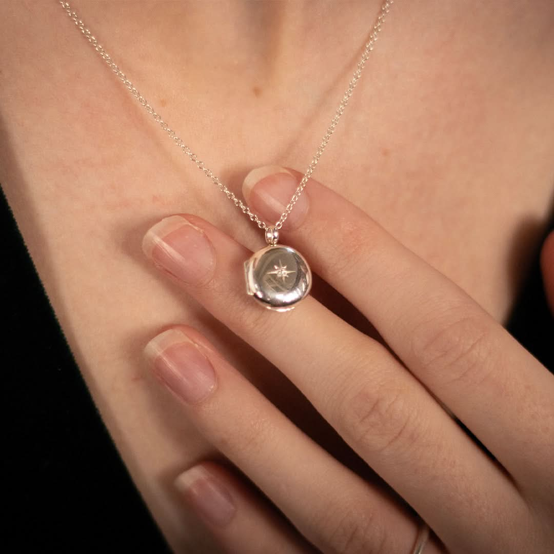 model wearing small round diamond locket in silver