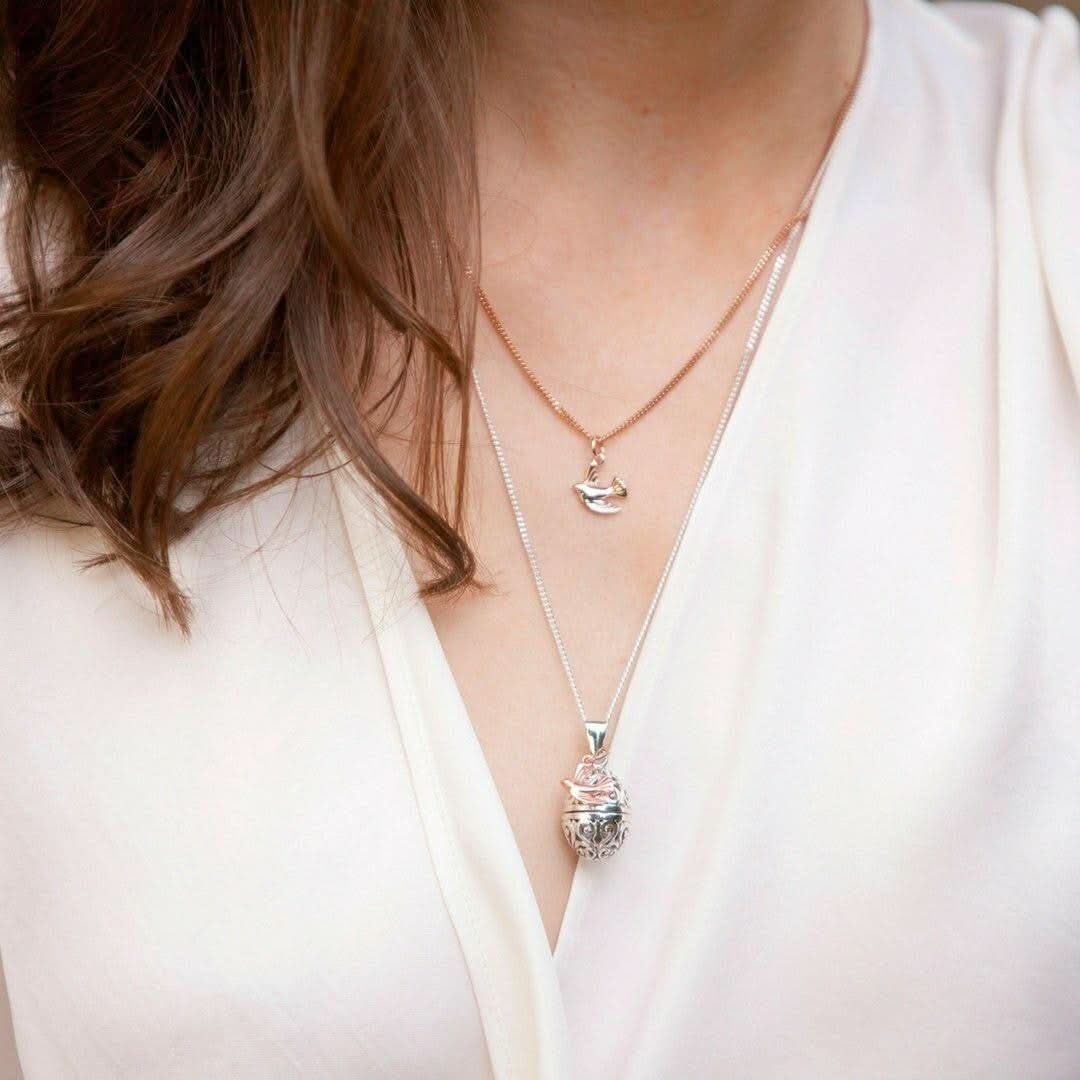 closeup of model wearing bird locket in silver