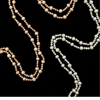 two eternal pearl necklaces on a black background