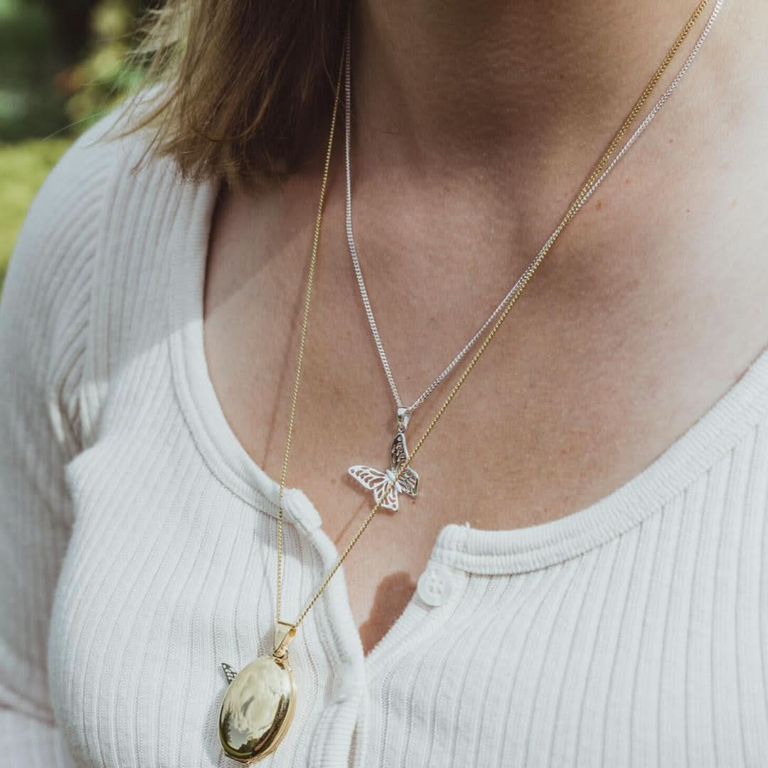 close up of model wearing butterfly pendant in silver 