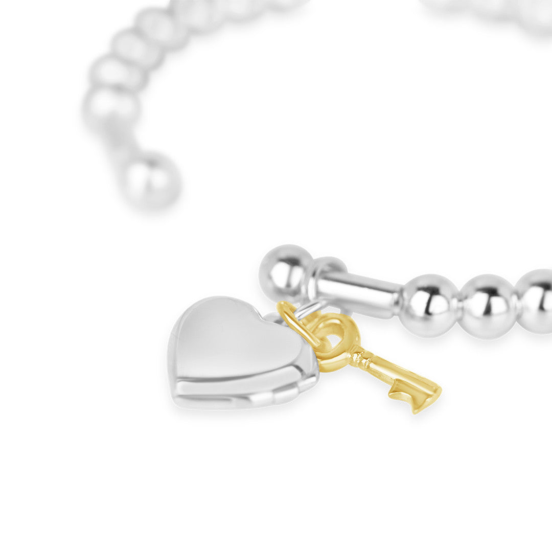 close up of heart locket bangle in silver on a white background