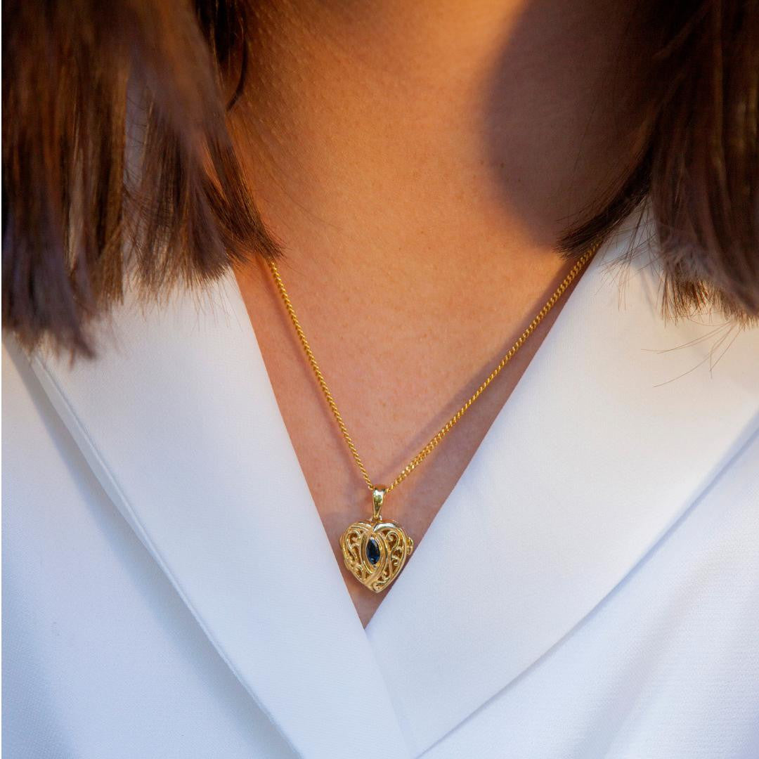 model wearing sapphire heart locket in gold