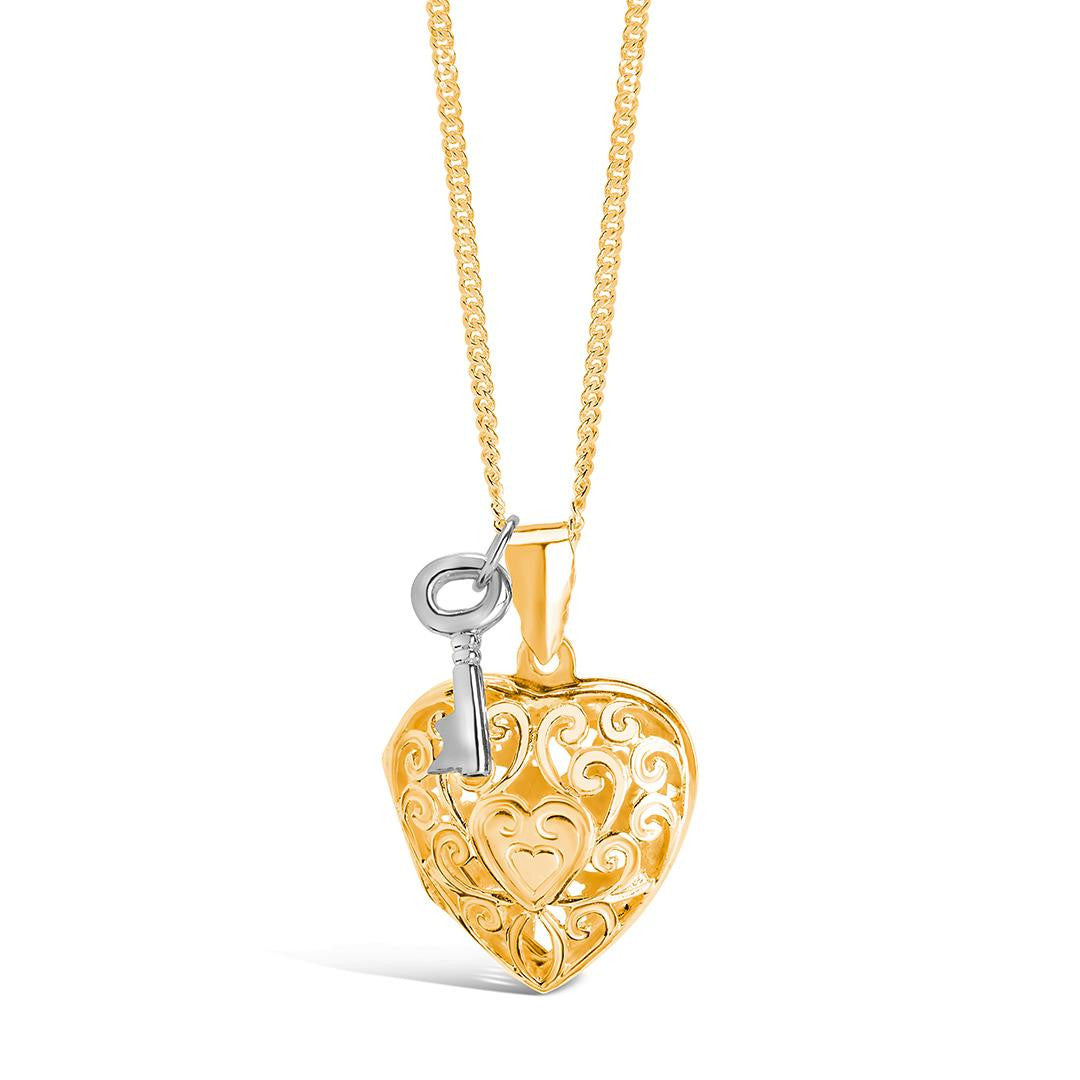 key locket in gold with silver key charm attached on a white background