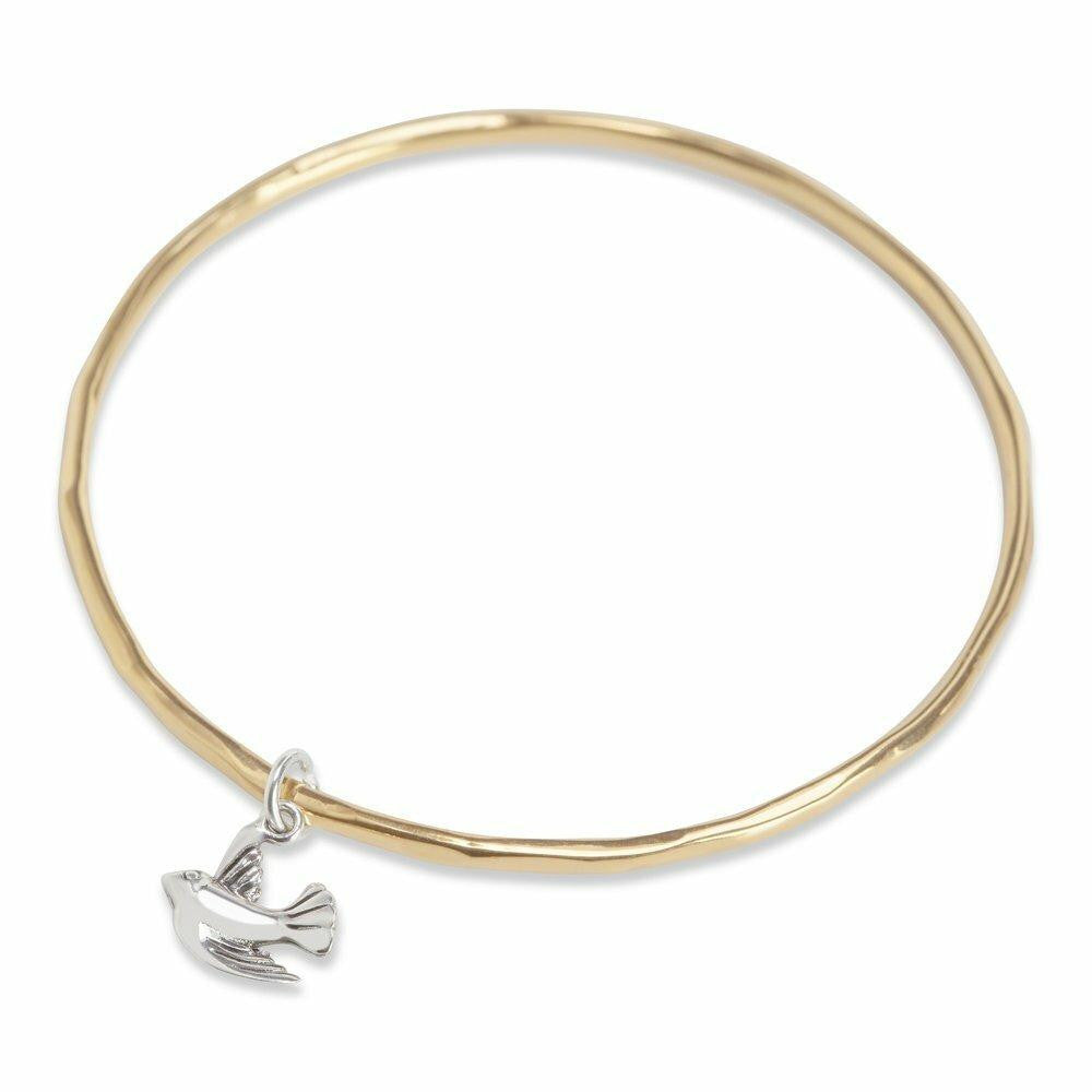 gold bangle with silver bird charm on a white background