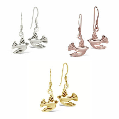silver, gold and rose gold bird earrings on a white background