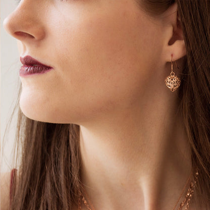 close up of model wearing rose gold heart earrings 