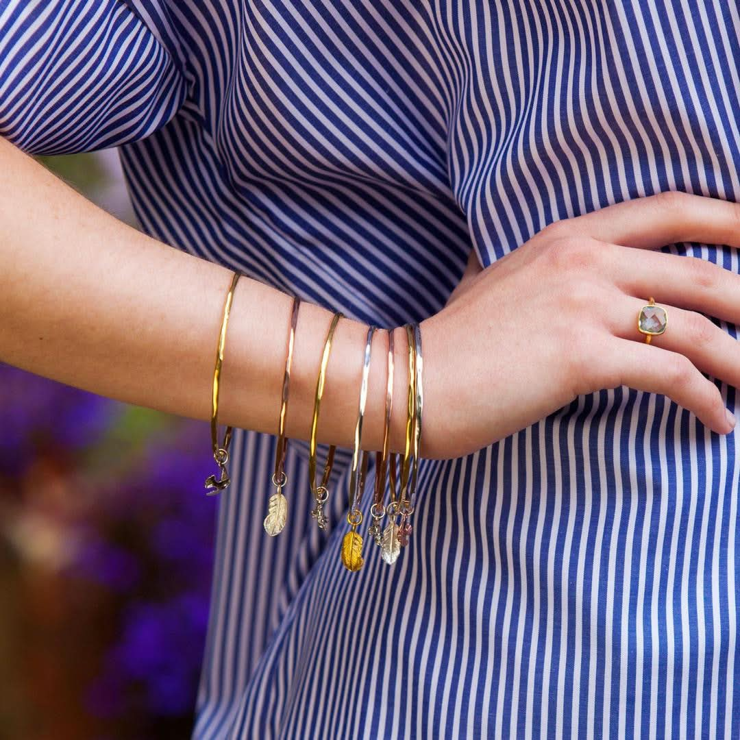 close up of model wearing feather bangles