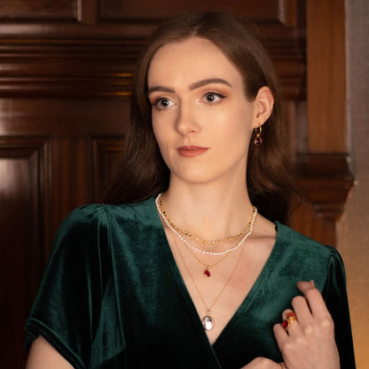 model wearing garnet charm necklace in gold