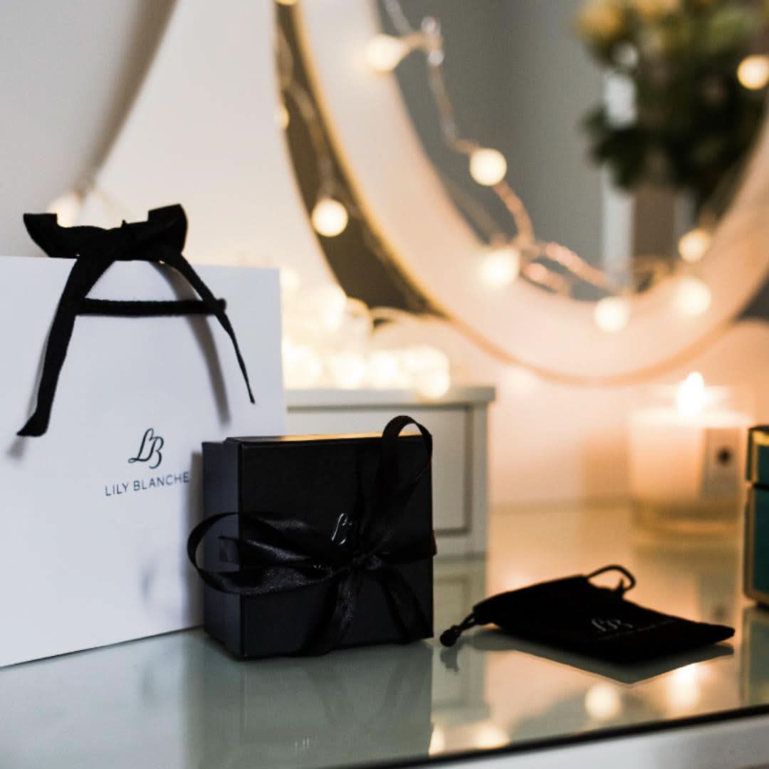 Lily Blanche gift box, gift bag and anti-tarnish bag sitting on a vanity table 