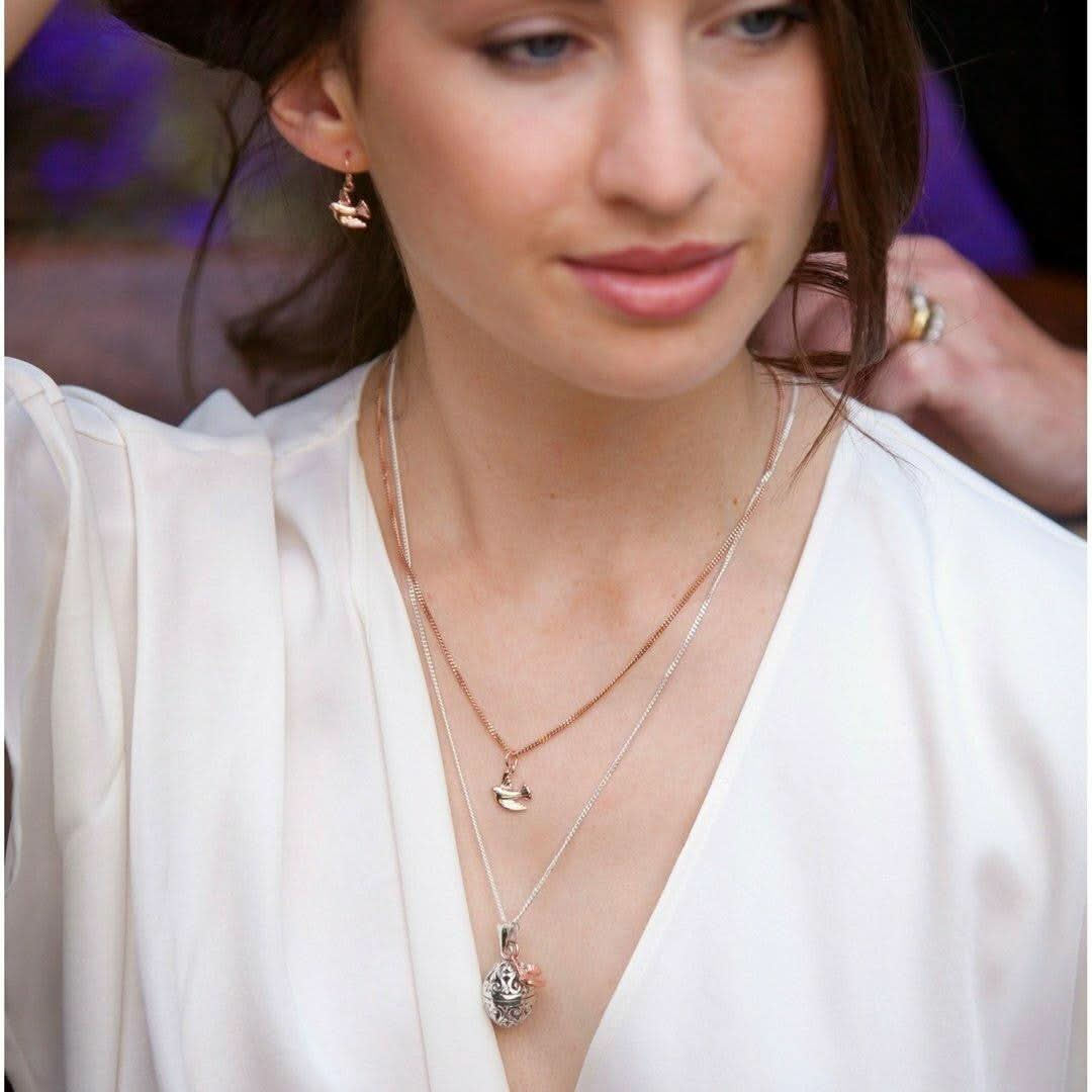 model wearing silver bird locket with bird charm