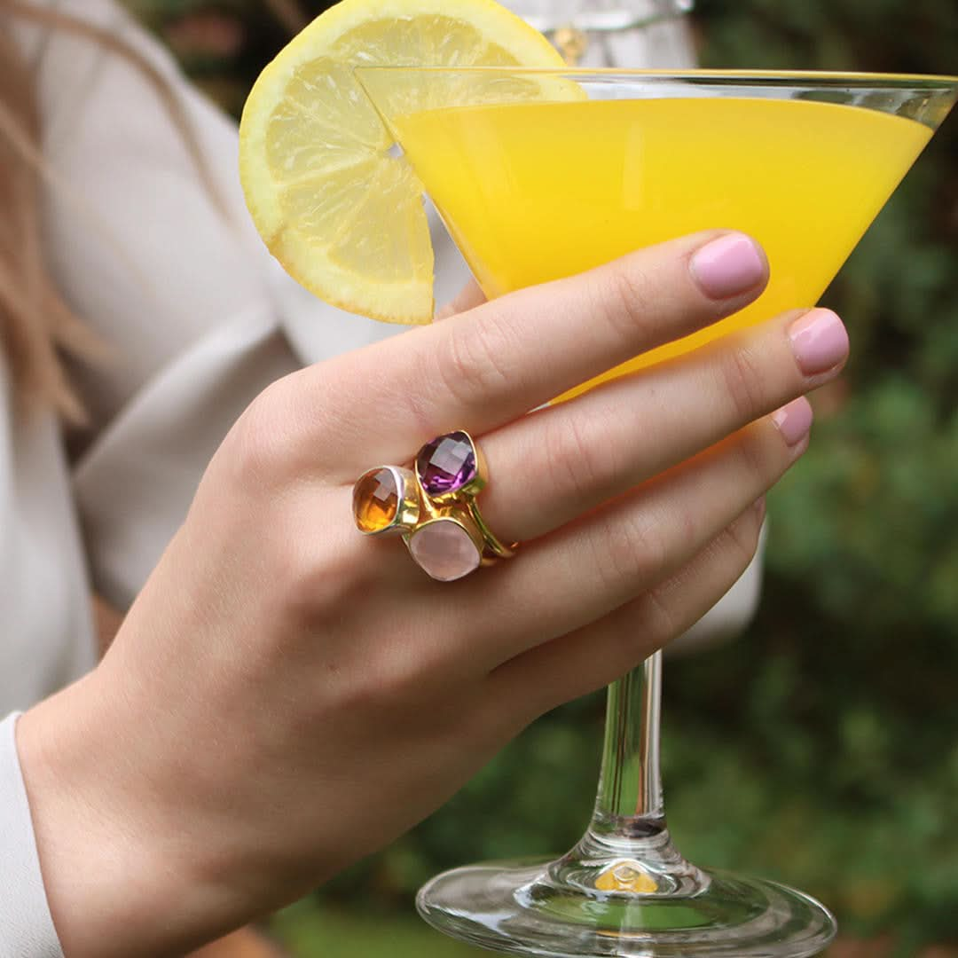 close up of model wearing three cocktail rings in gold 