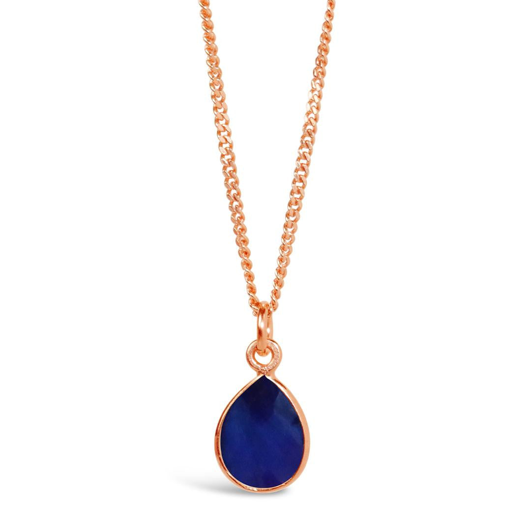 sapphire charm necklace in rose gold on a white background