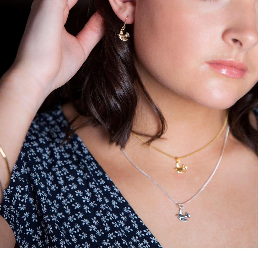 model wearing bird pendant in silver