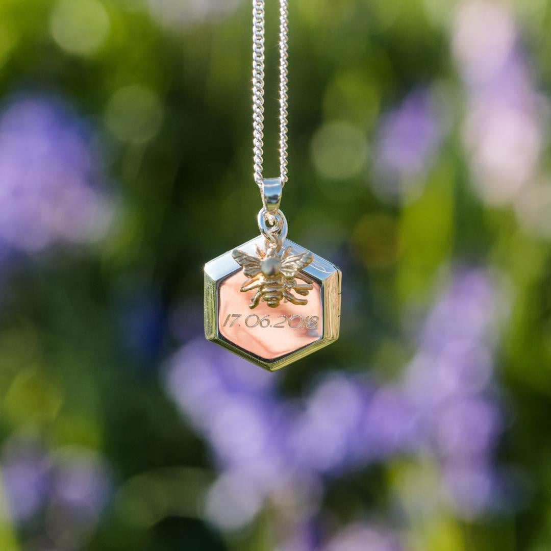locket in silver engraved with message with flowers in the background