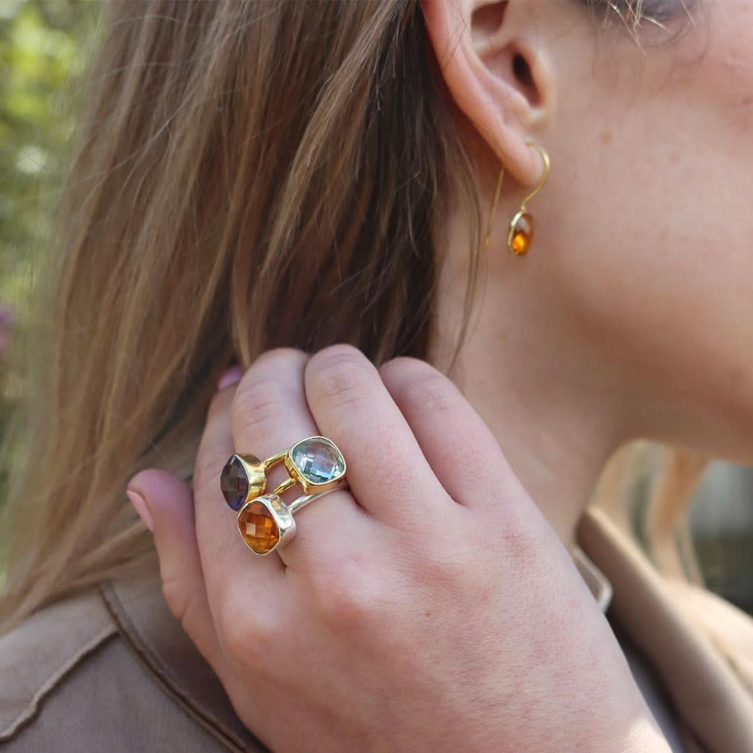 model wearing blue topaz cocktail ring in gold