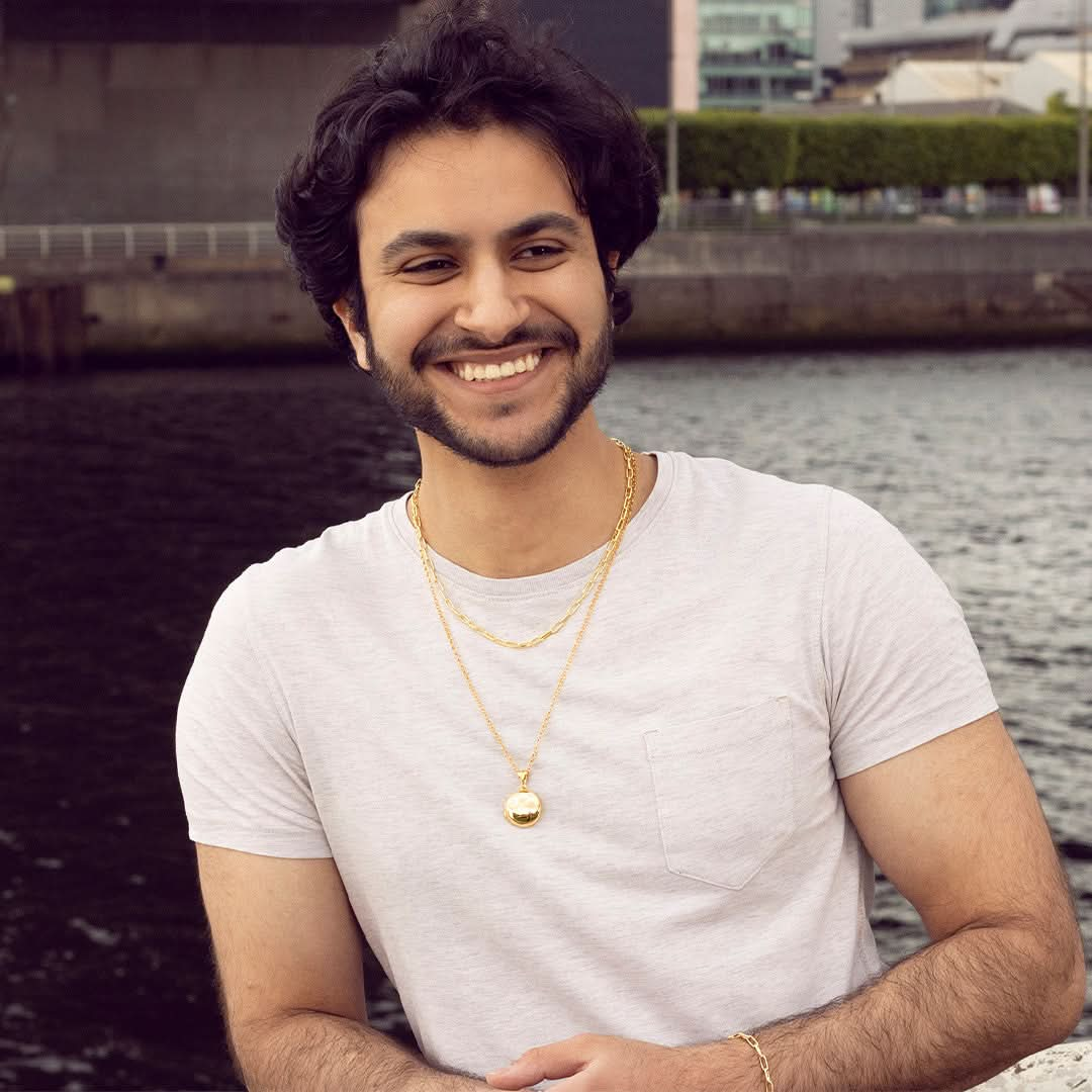 model wearing men's round locket necklace in gold  