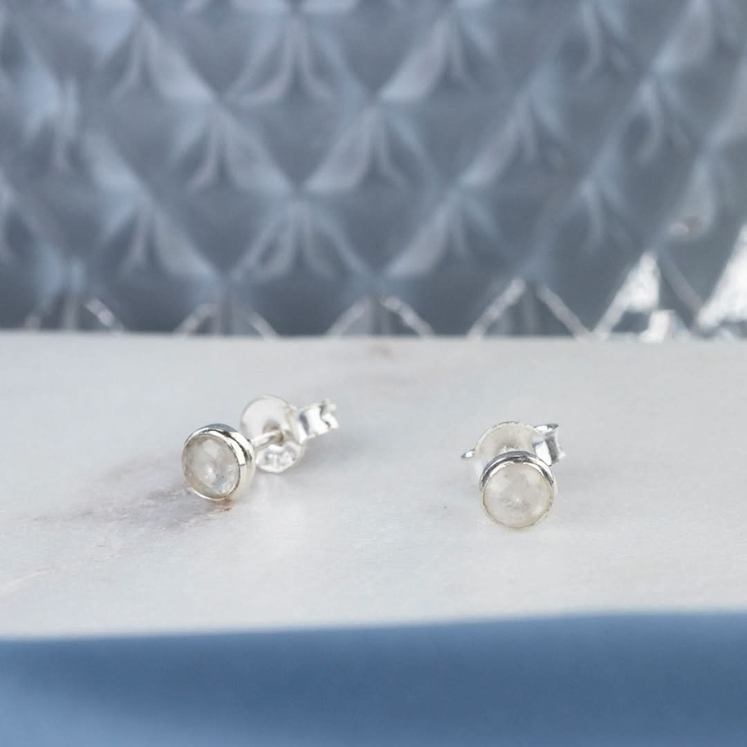 Silver moonstone stud earrings on a white platter