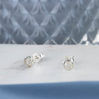 Silver moonstone stud earrings on a white platter