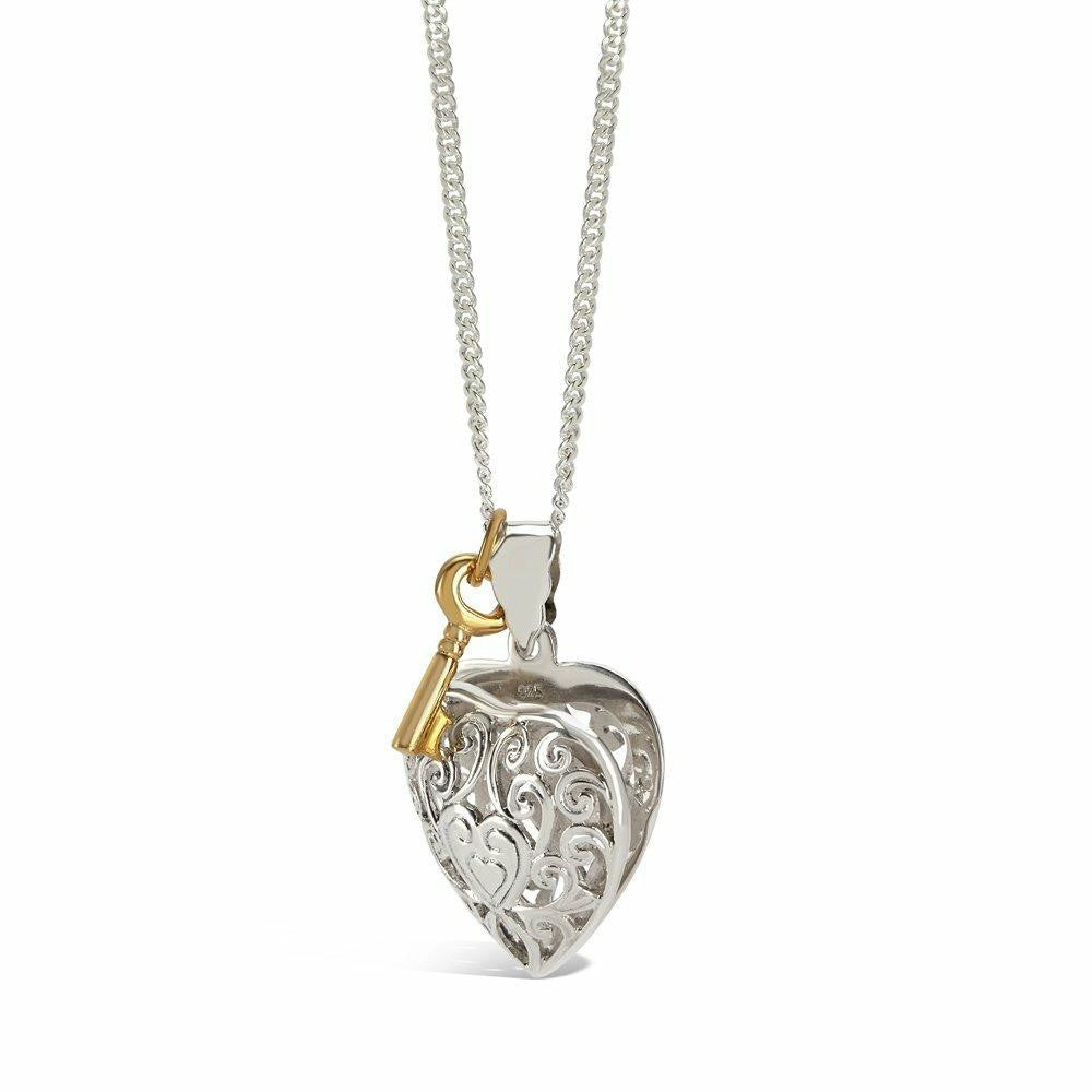 key locket in silver with gold key charm attached on a white background