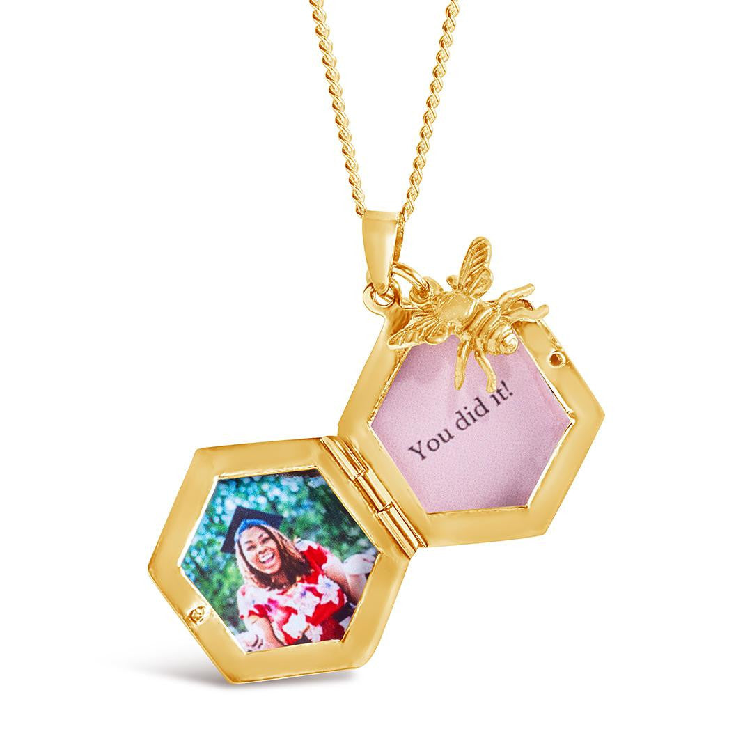 opened bee locket in gold with gold bee charm and photos inside