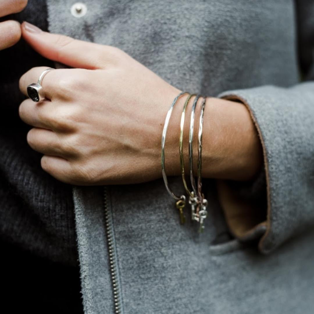close up of model wearing four key bangles