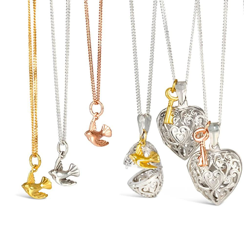 three bird pedants in gold next to bird and key lockets