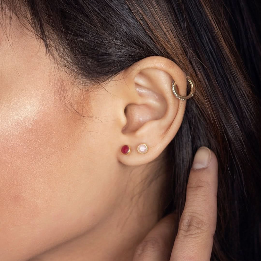 Lily Blanche rose gold moonstone stud earrings and ruby stud earrings on a model