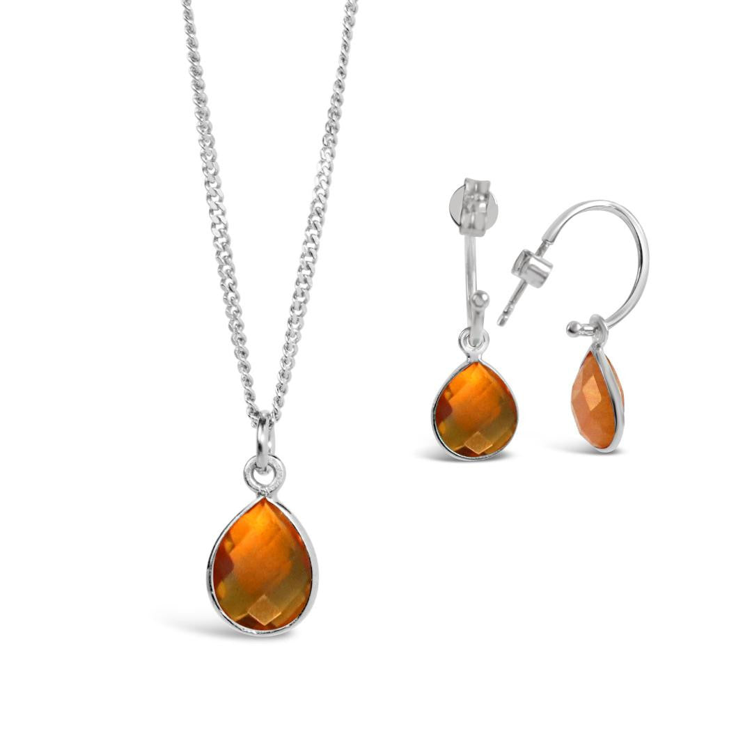 citrine charm necklace and drop hoop earrings in silver on a white background