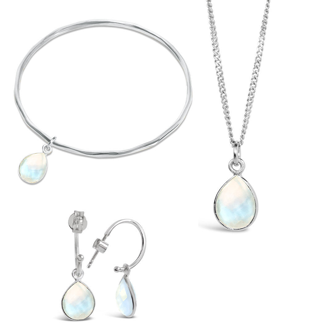silver moonstone charm bangle with matching necklace and drop hoop earrings on a white background