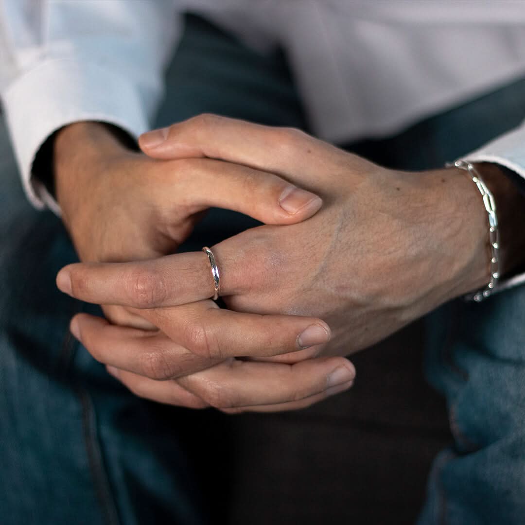 closeup of model wearing men's hammered rose gold ring  
