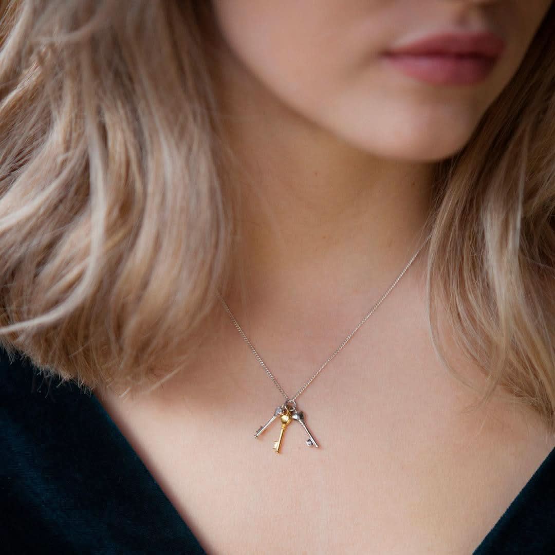 model wearing bunch of key pendants on silver chain