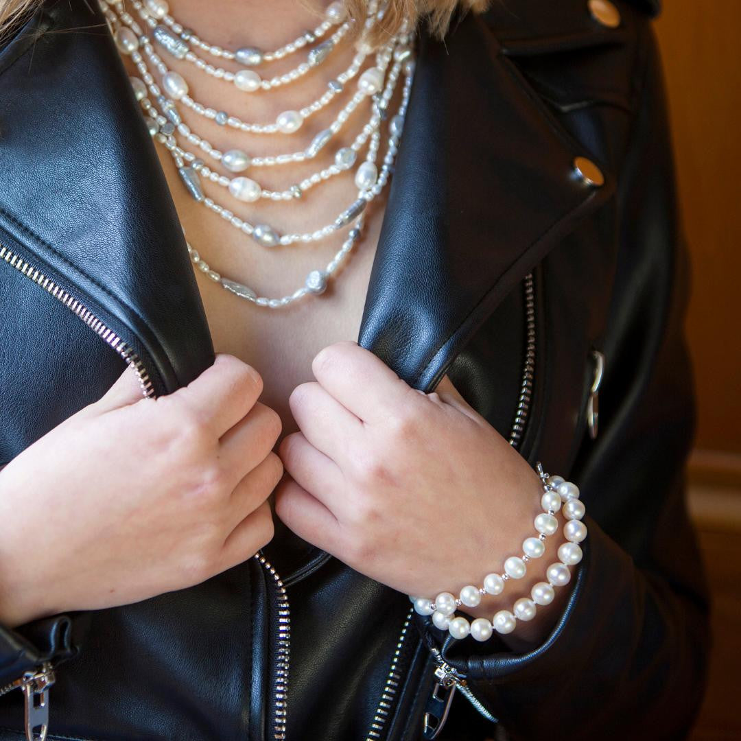 model wearing two classic pearl bracelets in ivory  