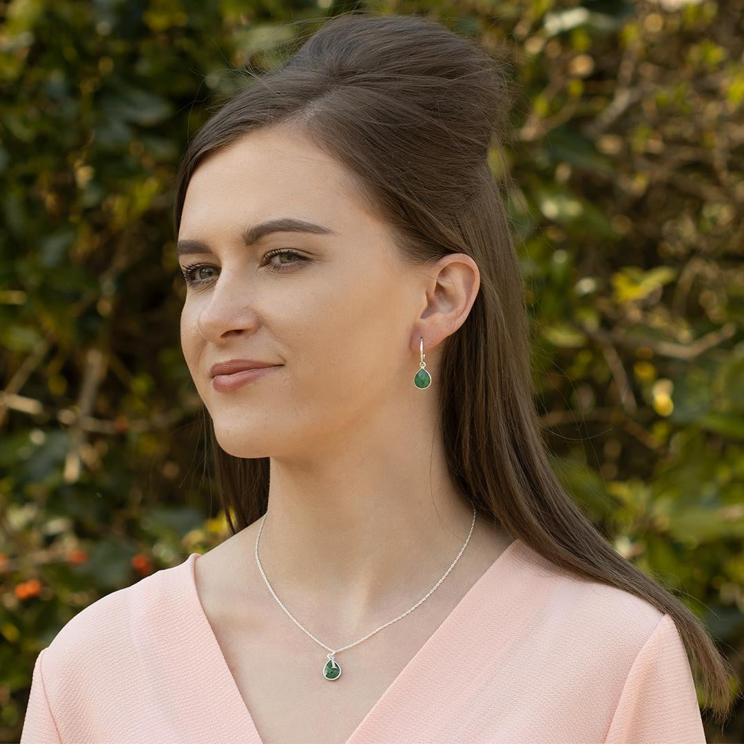 model wearing  tear drop emerald necklace on silver chain with initial charm