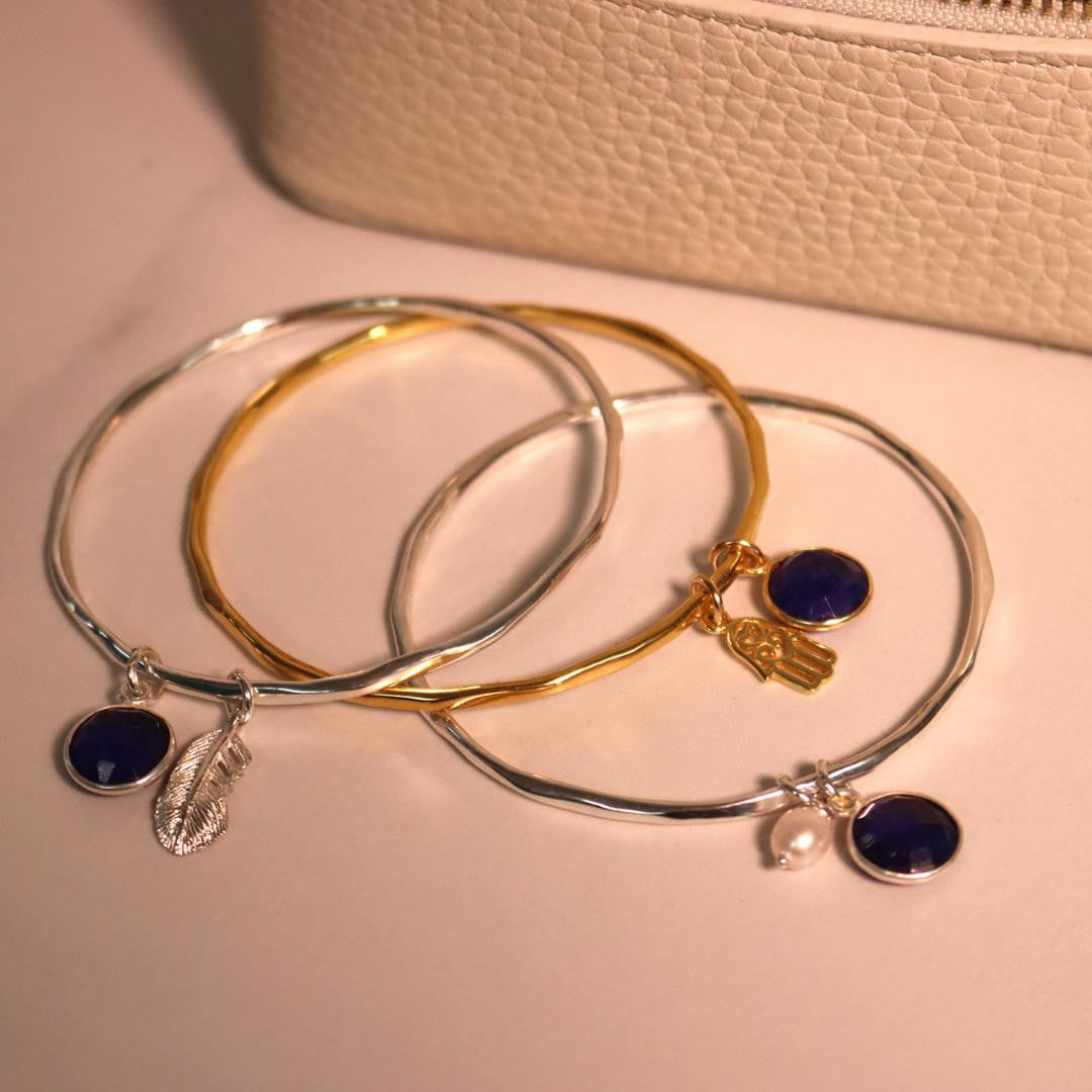 sapphire charm bangles with different charms attached 