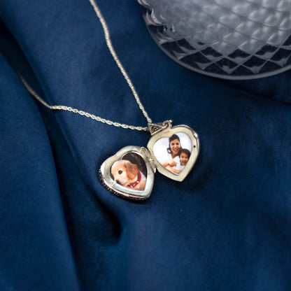 sapphire vintage heart locket in silver opened to reveal family photos on a blue piece of fabric