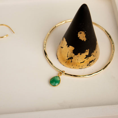 Emerald  bangle in a marble tray with black ring cone