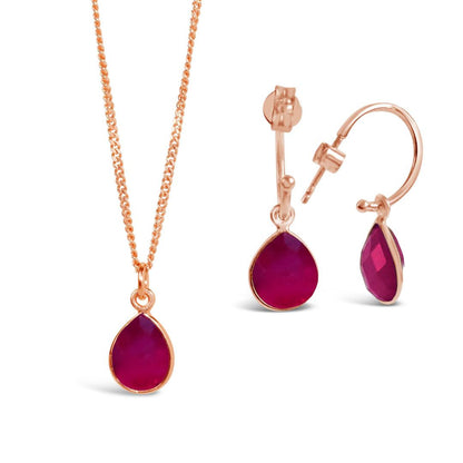 ruby drop hoop earrings in rose gold with matching necklace on a white background