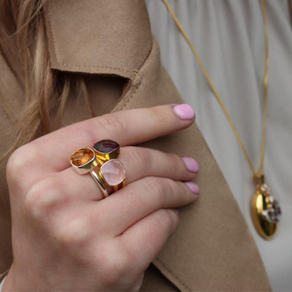 model wearing three cocktail rings in different metal types