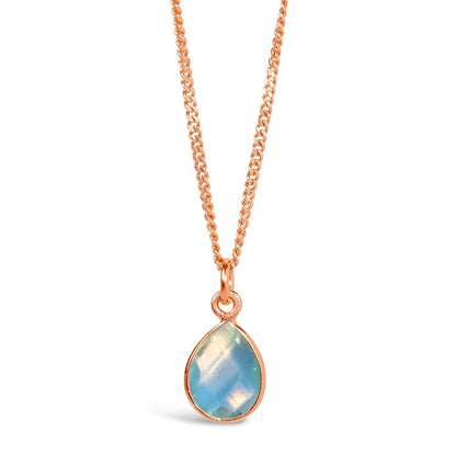 blue topaz charm necklace in rose gold on a white background