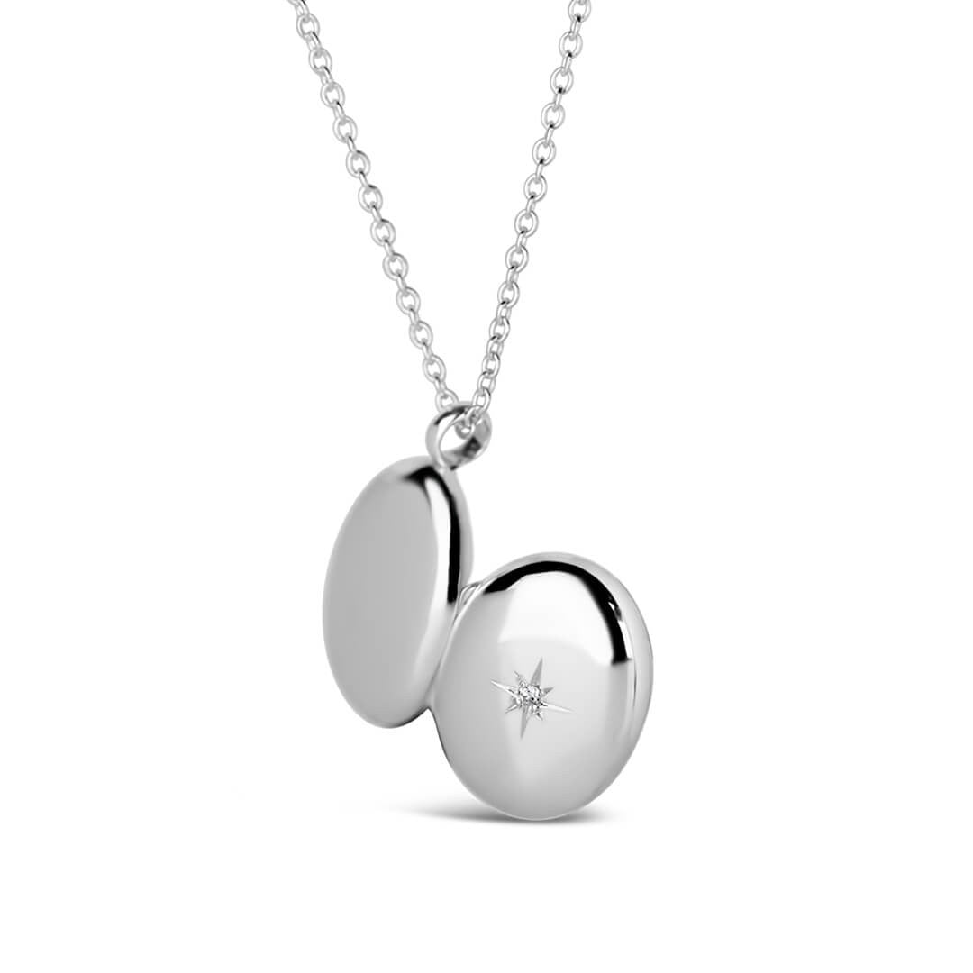 small oval diamond locket in silver opened to show back and front of locket
