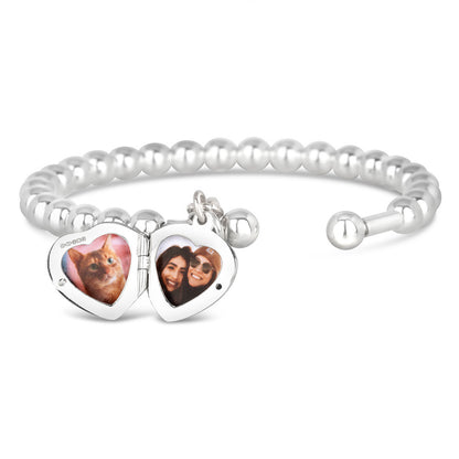 opened heart locket bangle in silver on a white background